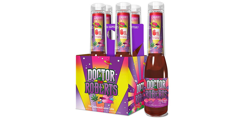 A purple, pink, and yellow box of four bottles of Doctor Roberts Cherry Cola, with a single bottle standing next to the box.